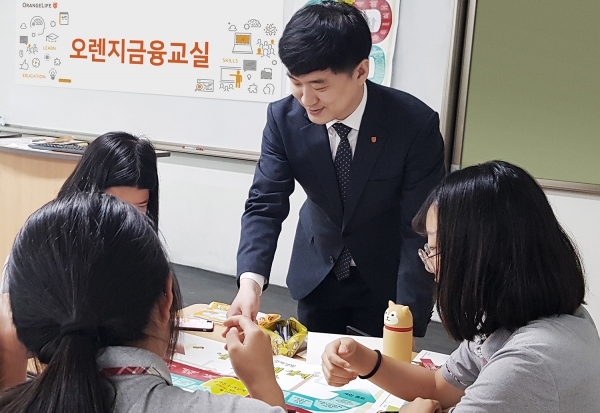 지난 5일 서울의 한 중학교에서 진행된 ‘오렌지금융교실’에서 오렌지라이프 FC가 진로설계 보드게임을 활용해 학생들에게 기회비용의 개념을 설명하고 있다. 사진=오렌지라이프 제공