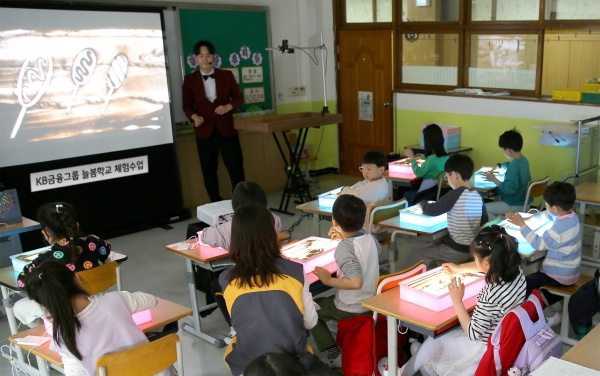 KB금융그룹은 지난 5일 경기도 성남시 분당구 수내초등학교에서 KB금융 직원이 함께하는 ‘늘봄학교 샌드아트 체험 수업’을 진행했다. 사진=KB금융그룹.