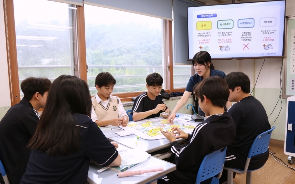 흥덕중학교 1학년 학생들이 단국대 환경교육단 대학생과 함께 환경 교육을 실시하고 신재생에너지 교구를 활용해 게임을 진행하고 있다. 사진=단국대.