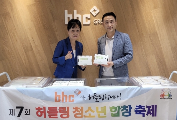 bhc 치킨이 '제7회 허들링 청소년 합창 축제'에 치킨을 기부하는 전달식을 가진 후, bhc 아카데미 한성민 팀장(오른쪽)과 서울시 문전자 봉사단장이 기념 촬영을 하고 있다. 사진=bhc 치킨